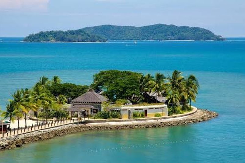 A small resort island fringed with palms in a turquoise sea